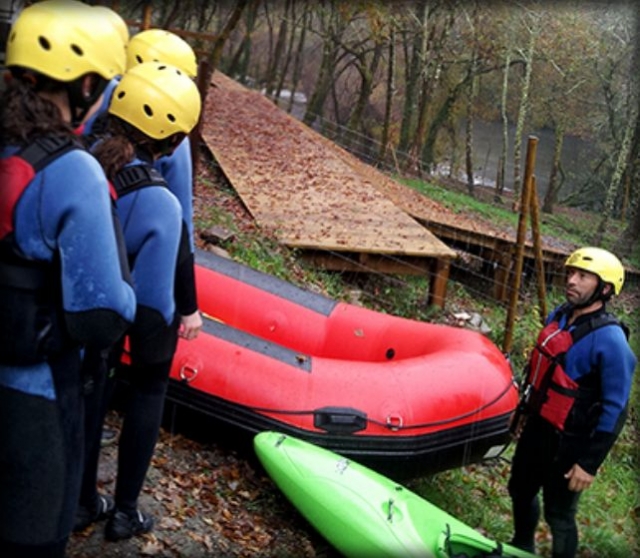 grupo de personas mirando a una embarcacion de rafting